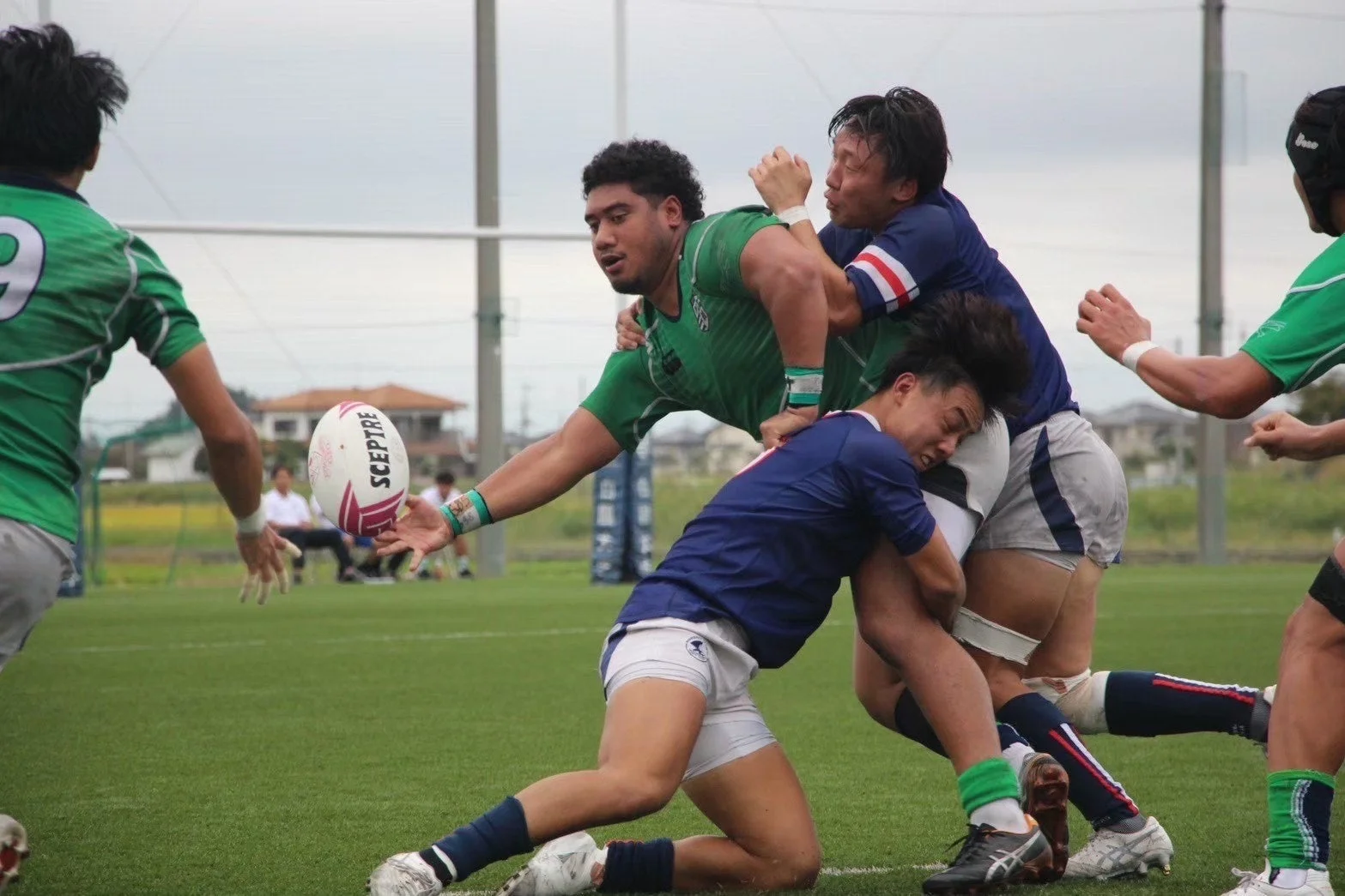 ラグビーの試合中、激しくぶつかり合う選手たち