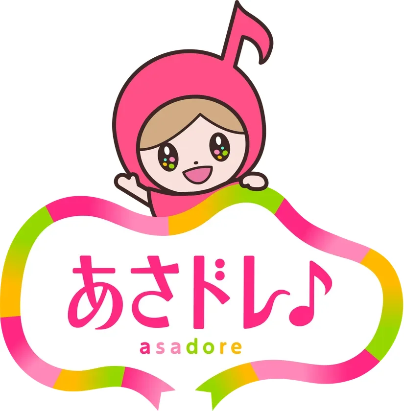 ピンクの音符の帽子をかぶった可愛いキャラクターが、カラフルなリボンの上に「あさドレ♪」と書かれたロゴから顔を出して手を振っているイラストです。