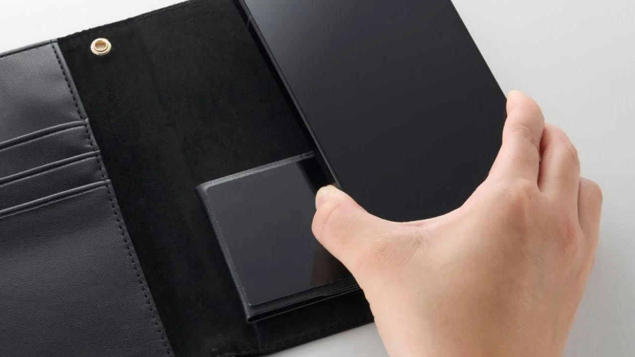 黒い手帳型ケースに黒いスマートフォンを装着している様子