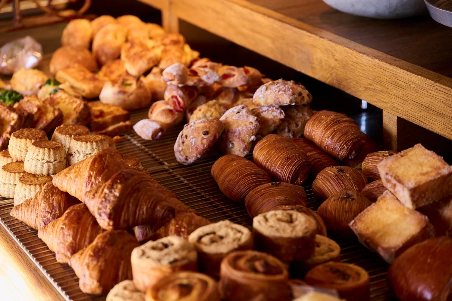 様々な種類の焼きたてパンや焼き菓子が豊富に並べられたベーカリーの棚