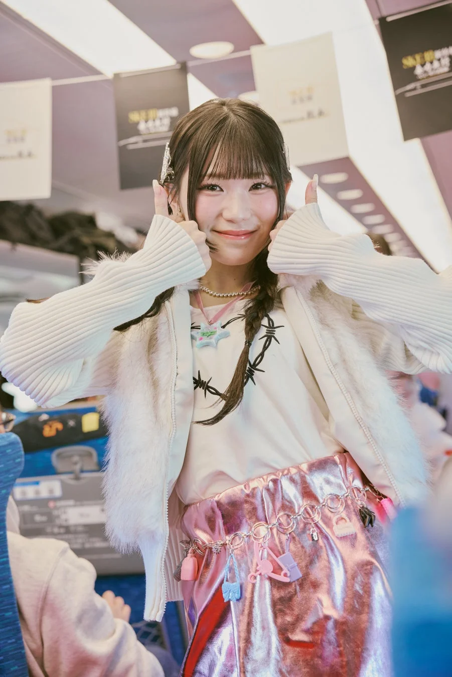 白いジャケットとピンクのスカートの女性