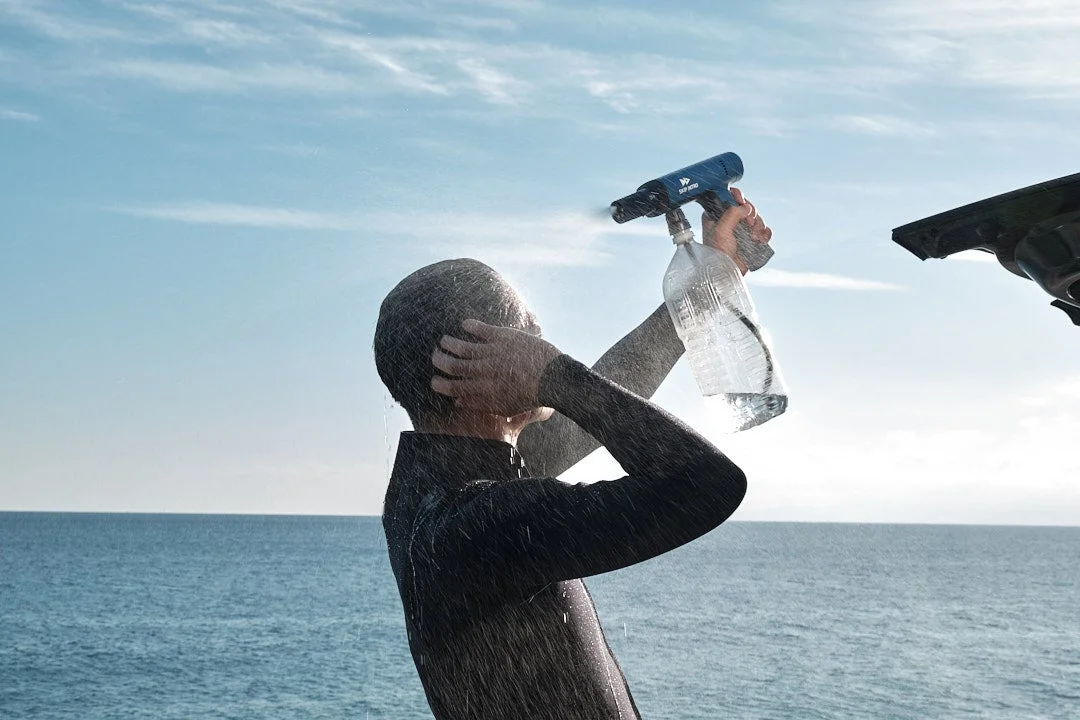 ウェットスーツを着た人がシャワー