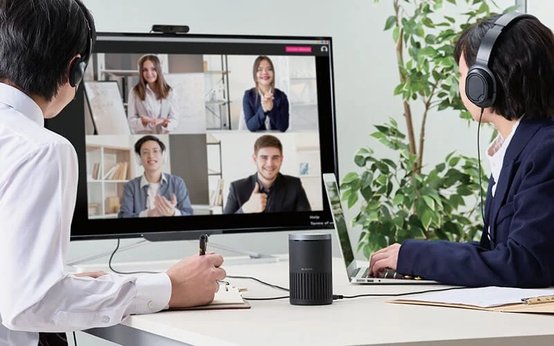 オフィスでヘッドセットを着用しWeb会議に参加するビジネスパーソン