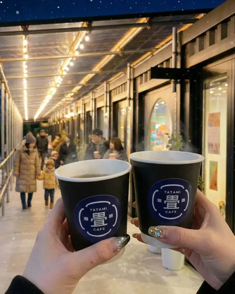 夜の屋外でコーヒーカップを持つ様子