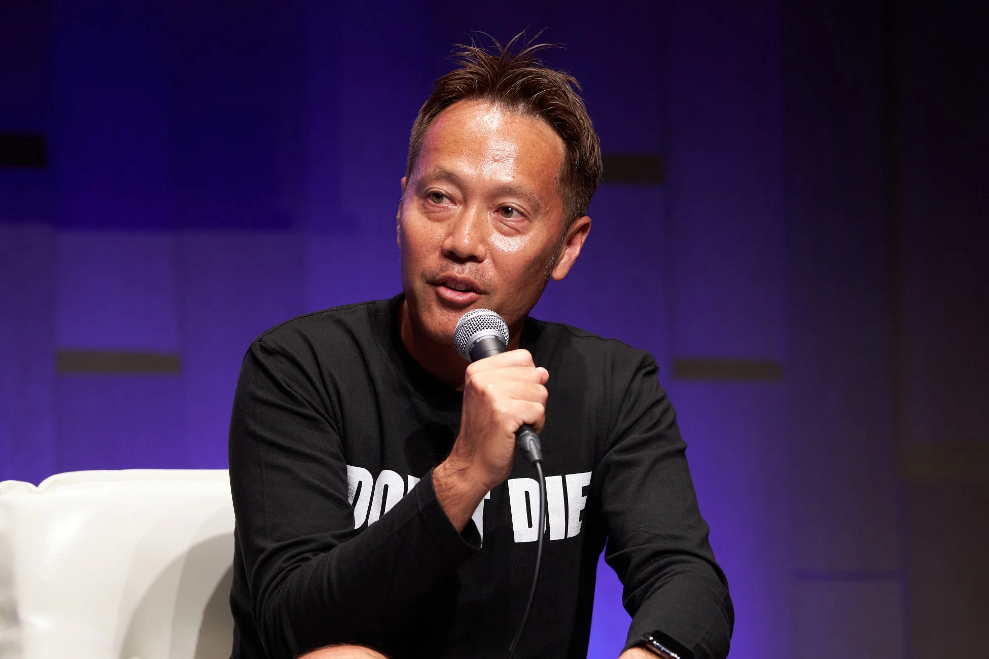 男性がマイクを持って話している様子