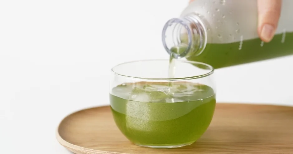 緑色の飲み物をグラスに注ぐ様子