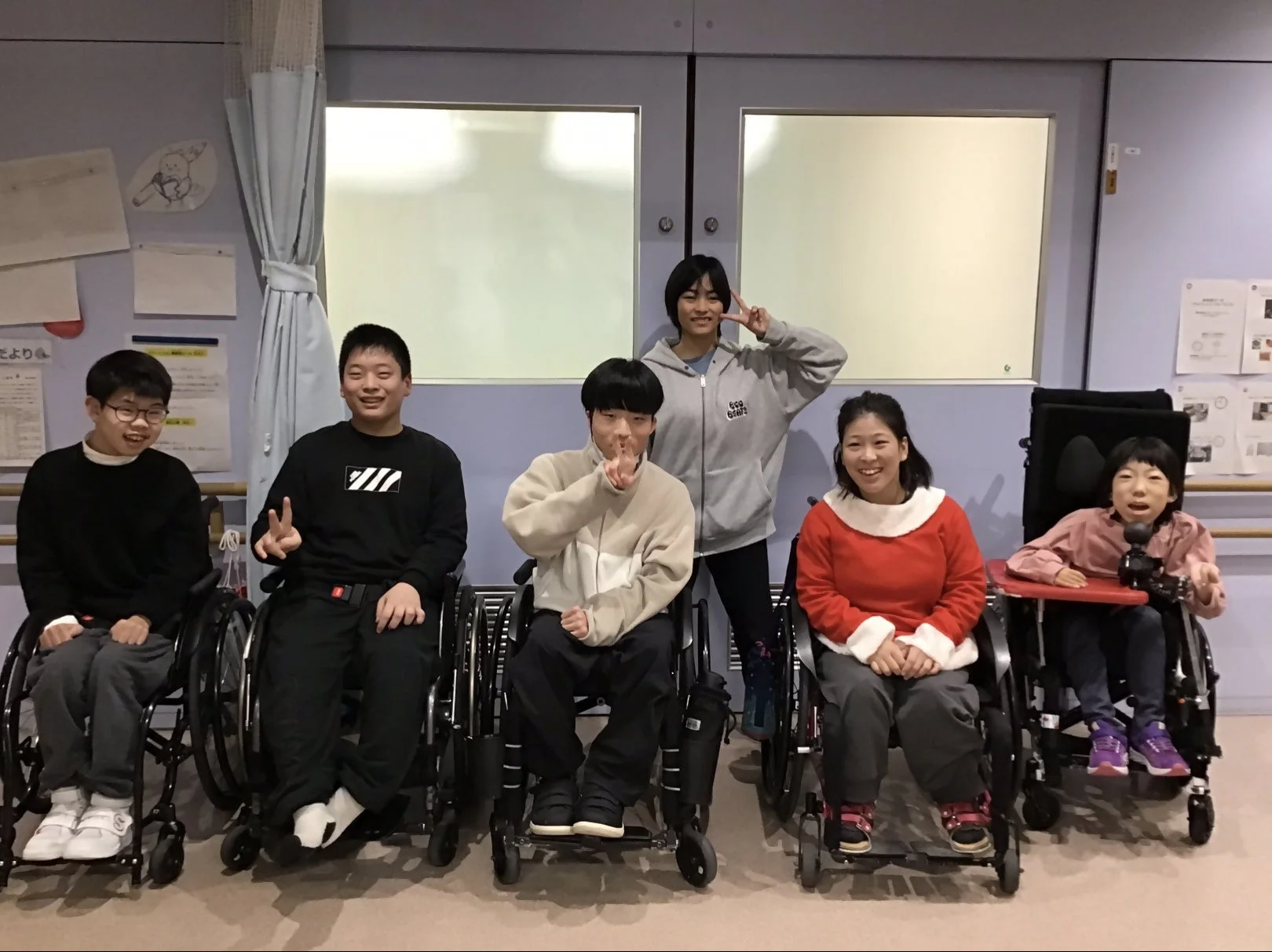 車椅子の参加者と笑顔でポーズをとる人々