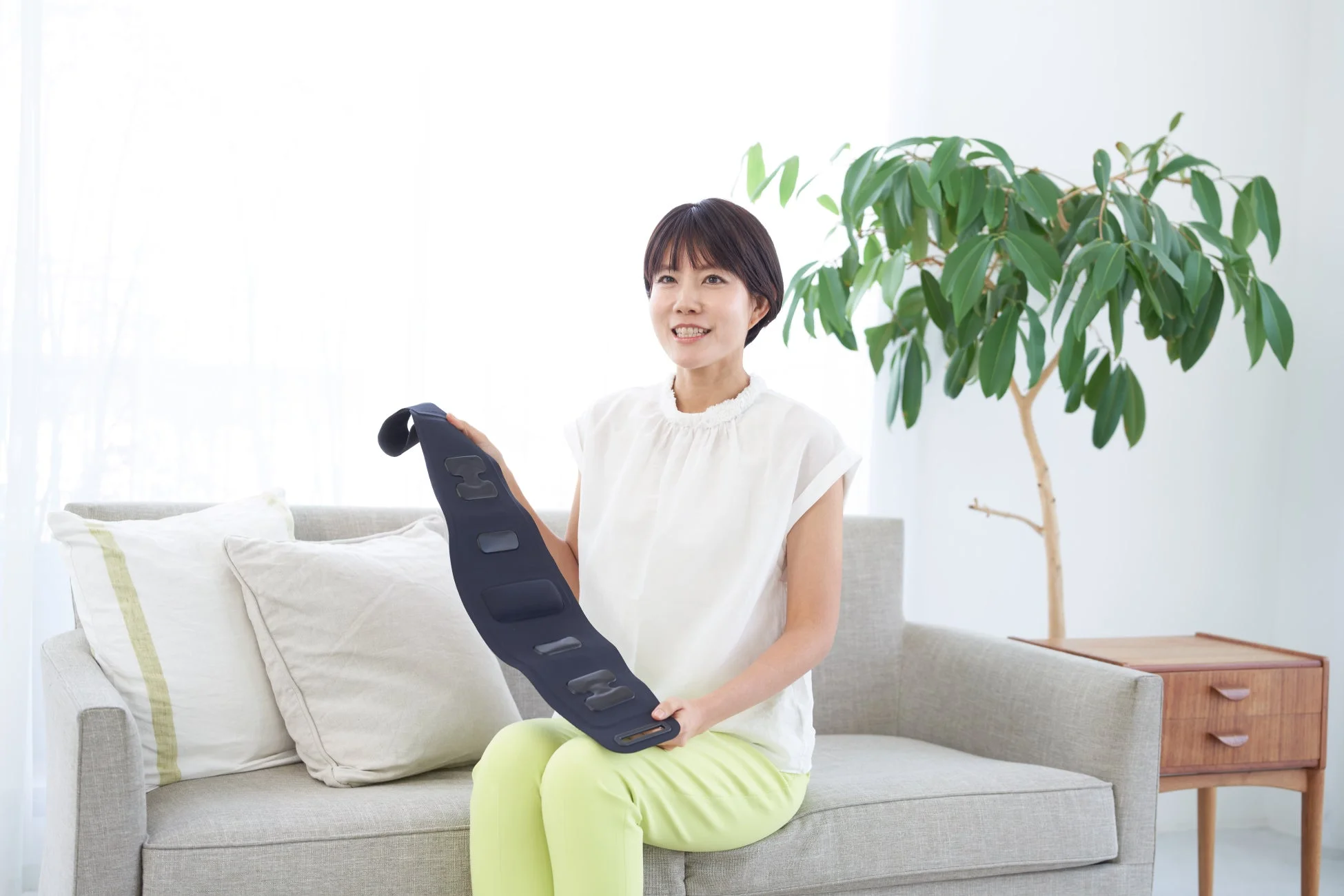 ソファに座ってくつろぐ女性とベルト