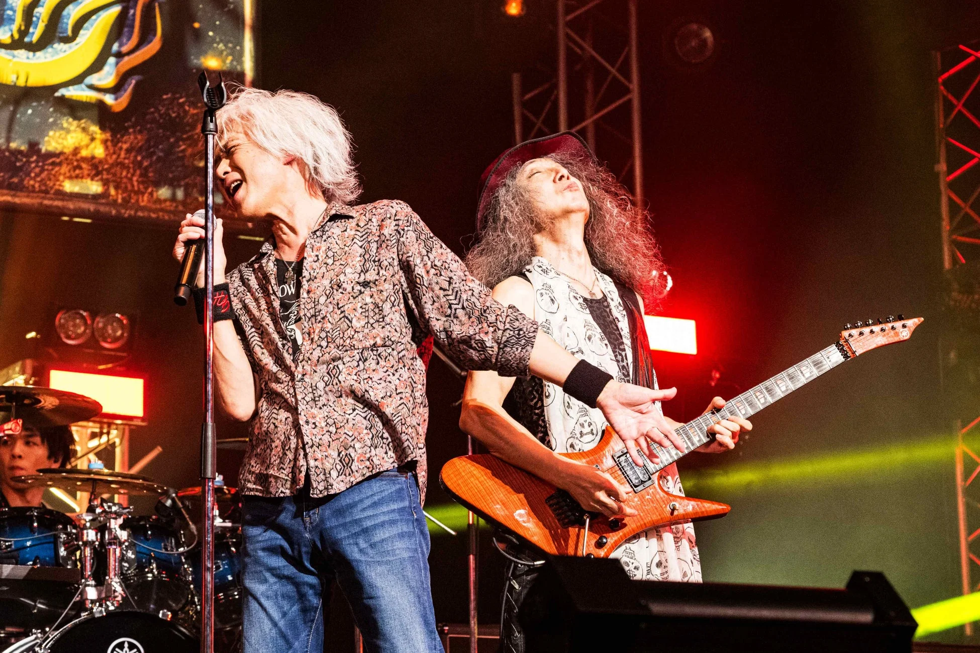 ライブステージで熱唱する歌手とギターを演奏するギタリスト