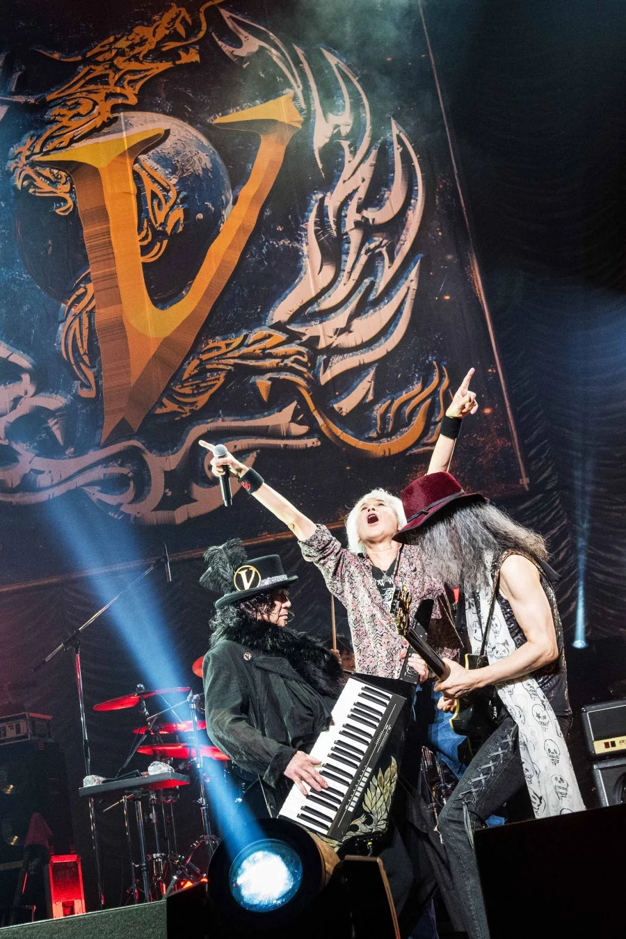 Vロゴを背景にしたステージでのパフォーマンス