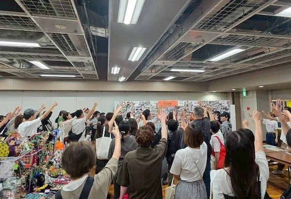 じゃんけん大会？参加者が手を上げている様子