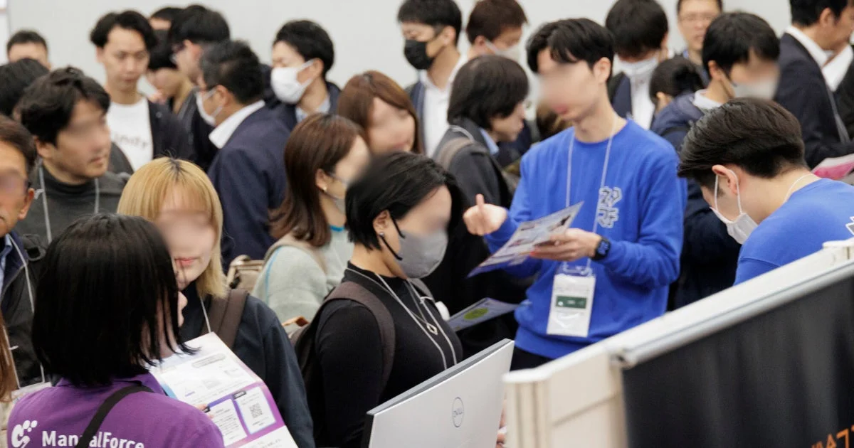 展示ブースで情報交換する来場者