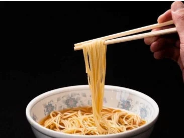 箸で持ち上げられた麺
