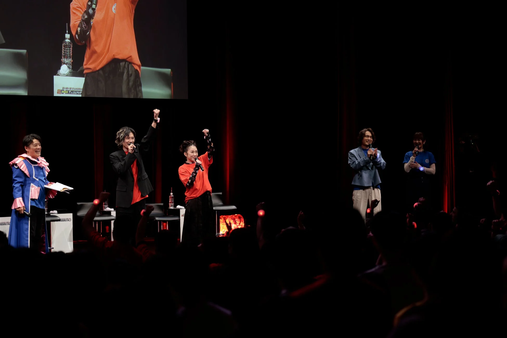 ステージとペンライトを掲げる観客、スクリーンには「20th PROJECT デュエルアカデミー」の文字