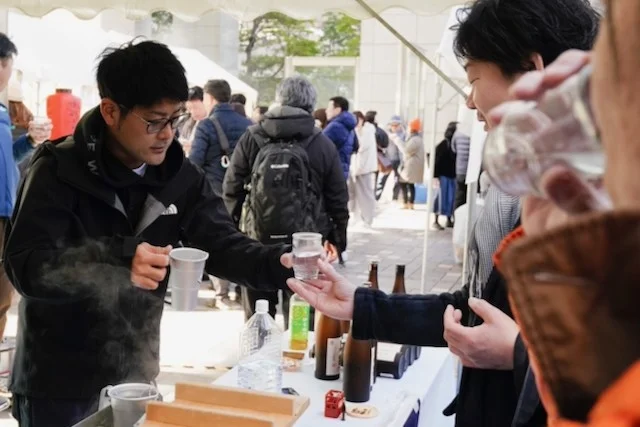 屋外で焼酎を注ぐ様子
