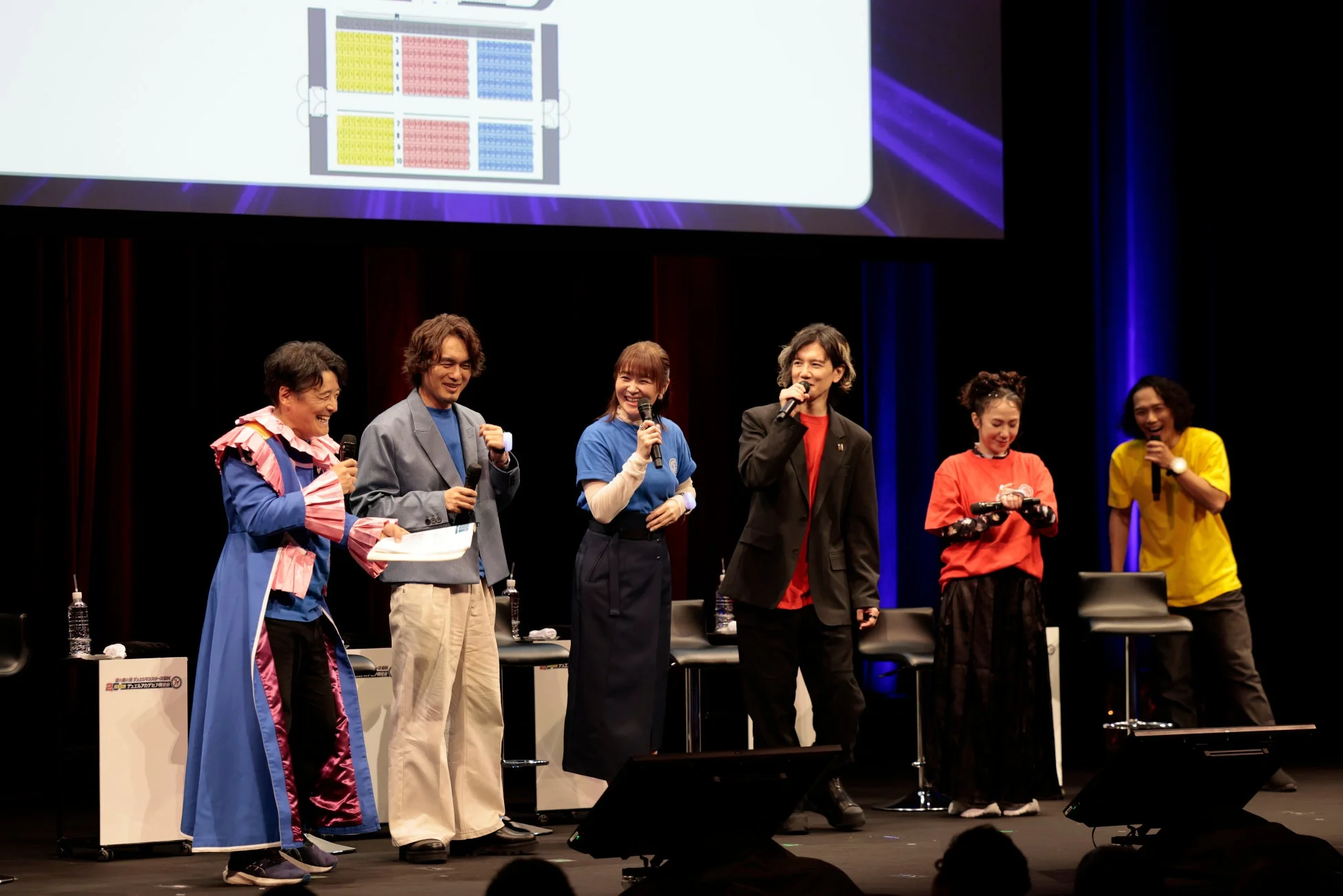 ステージ上でマイクを手に笑顔で話す登壇者たち