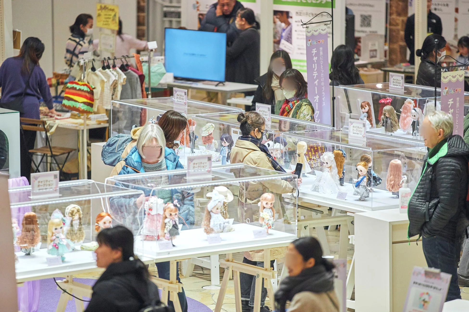 チャリティーオークションで人形を鑑賞する人々