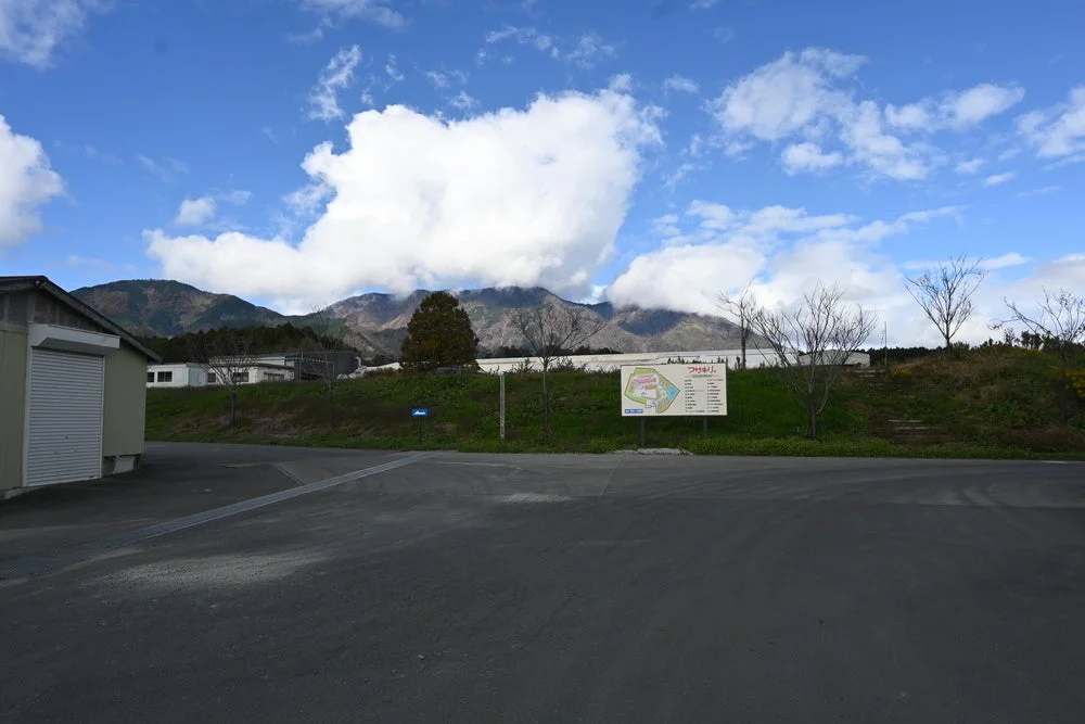 山と雲が広がる風景の中に道路と建物が見える