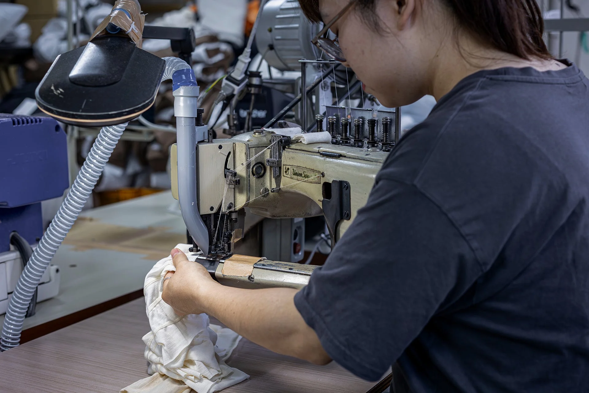 工業用ミシンで縫製作業をする女性