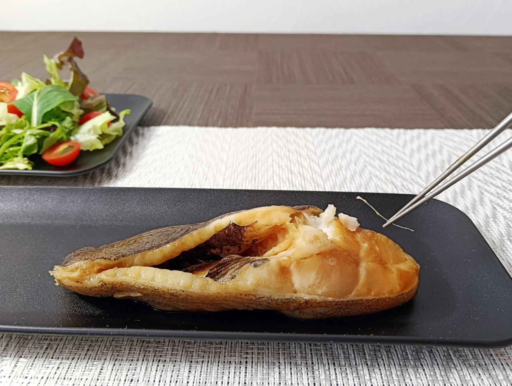 無玄箸で魚料理を食べる