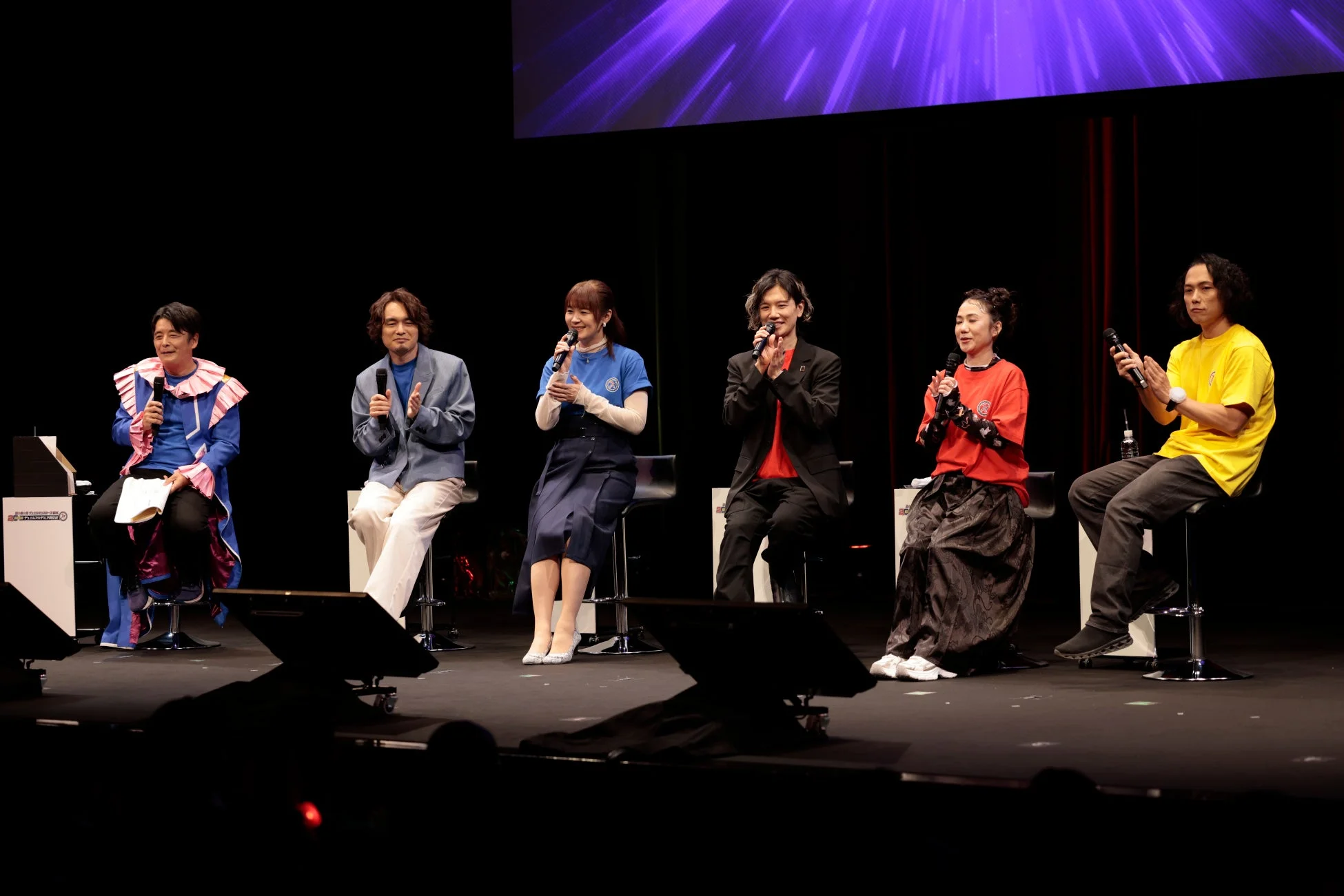 ステージでマイクを持つ登壇者たち