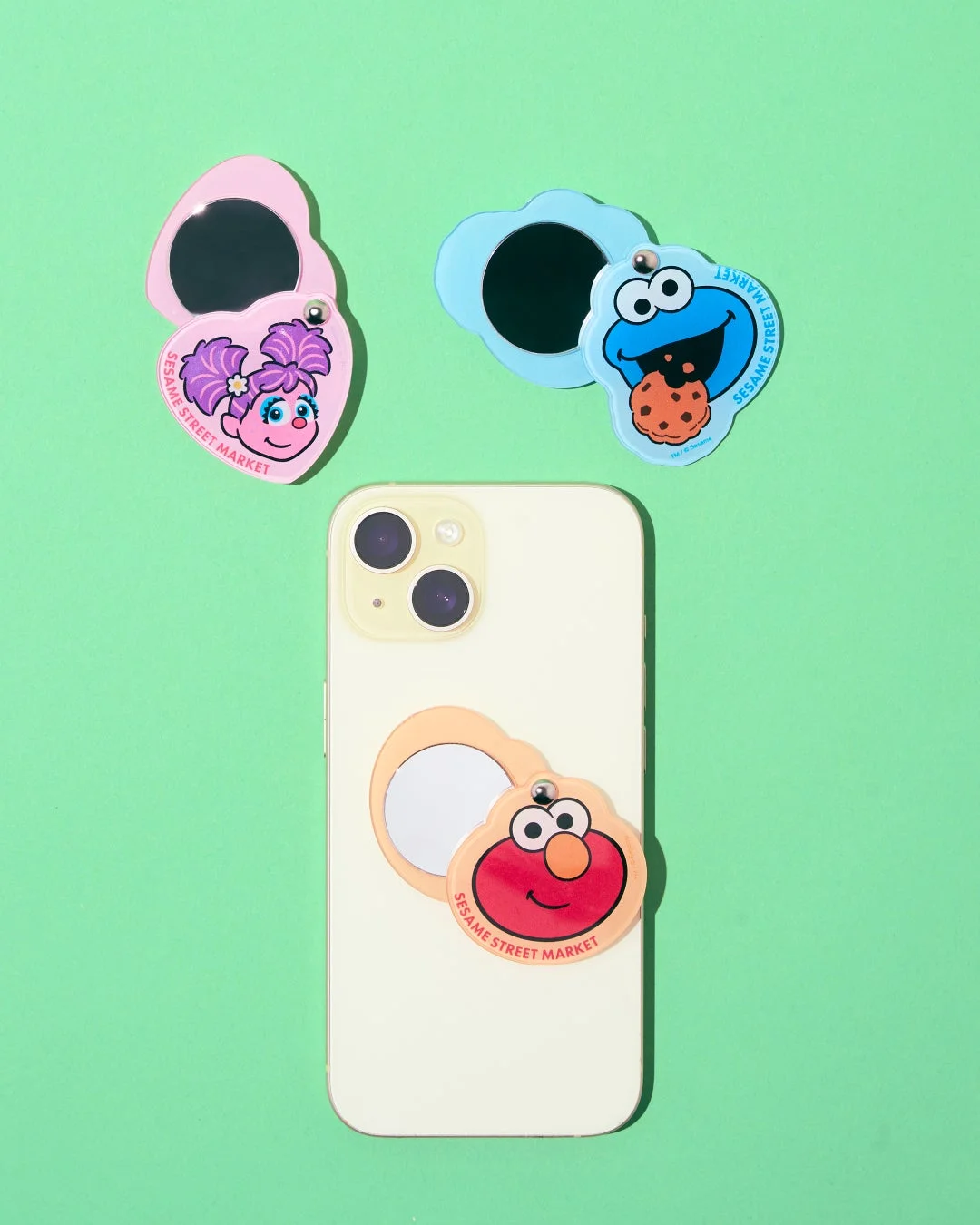 セサミストリートのエルモ、クッキーモンスター、アビー・カダビーがデザインされたスマートフォン用グリップミラーとコンパクトミラー
