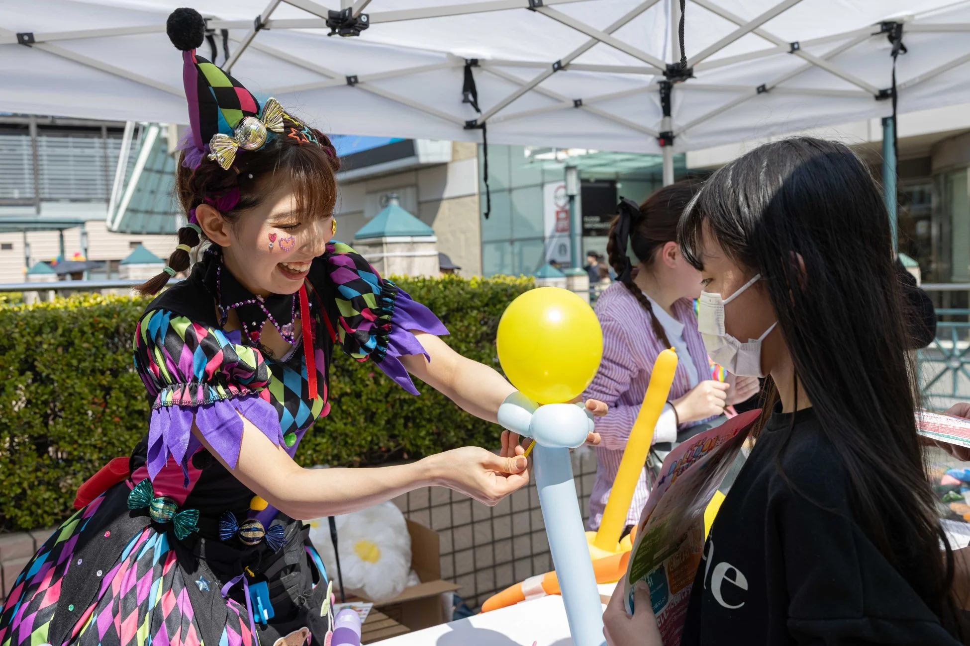 イベントでバルーンアートを渡すパフォーマー