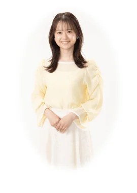 明るい黄色のブラウスと白いスカートを着用した、笑顔の若い日本人女性