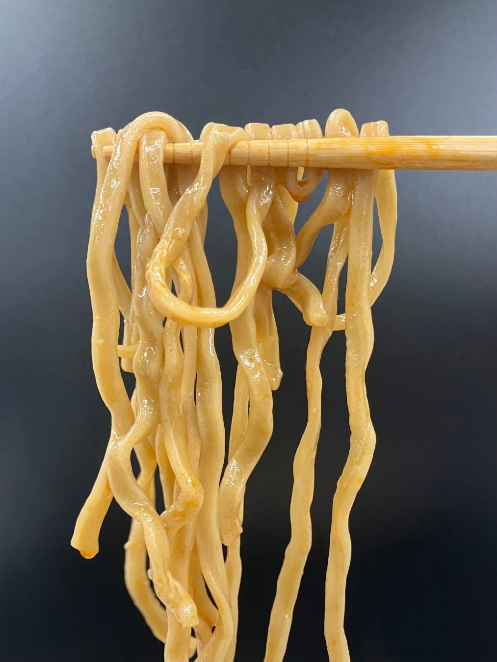 箸で持ち上げられた麺