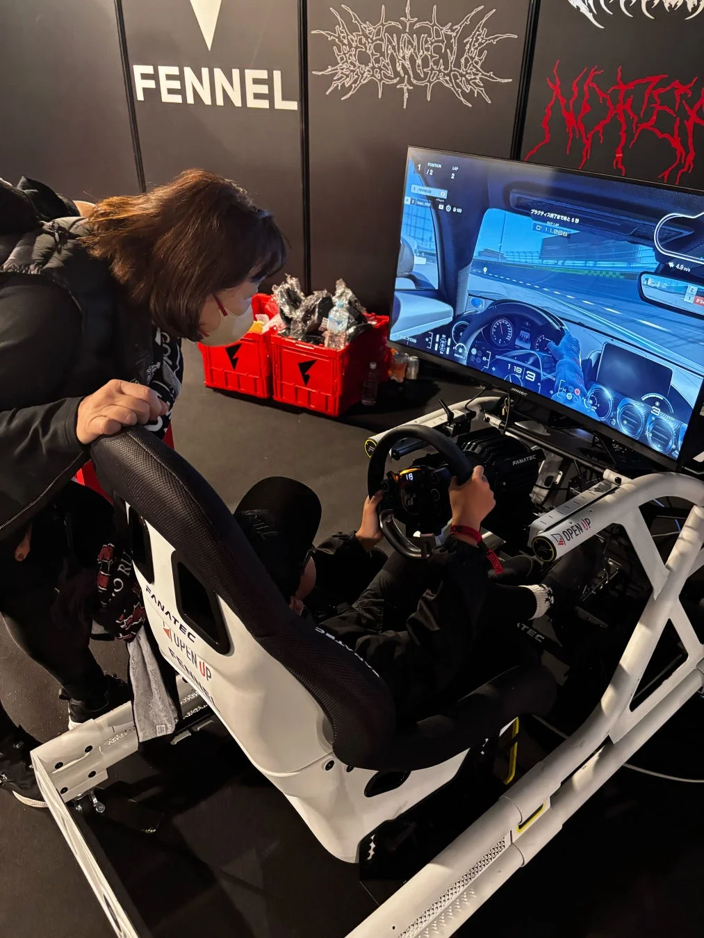 シミュレーターを操作する人物とそれを見守る人物