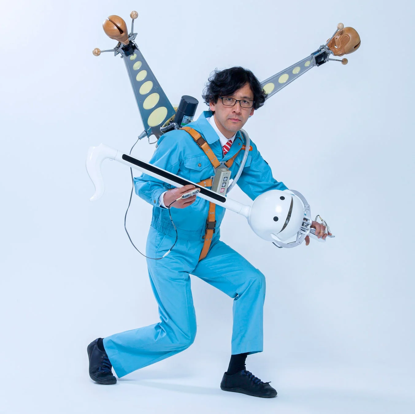 オタマトーンのような楽器を抱える明和電機の男性