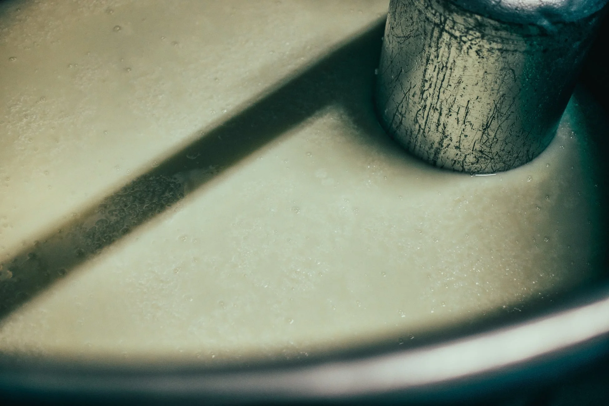 液体の中に金属製の円筒が浸かっている様子