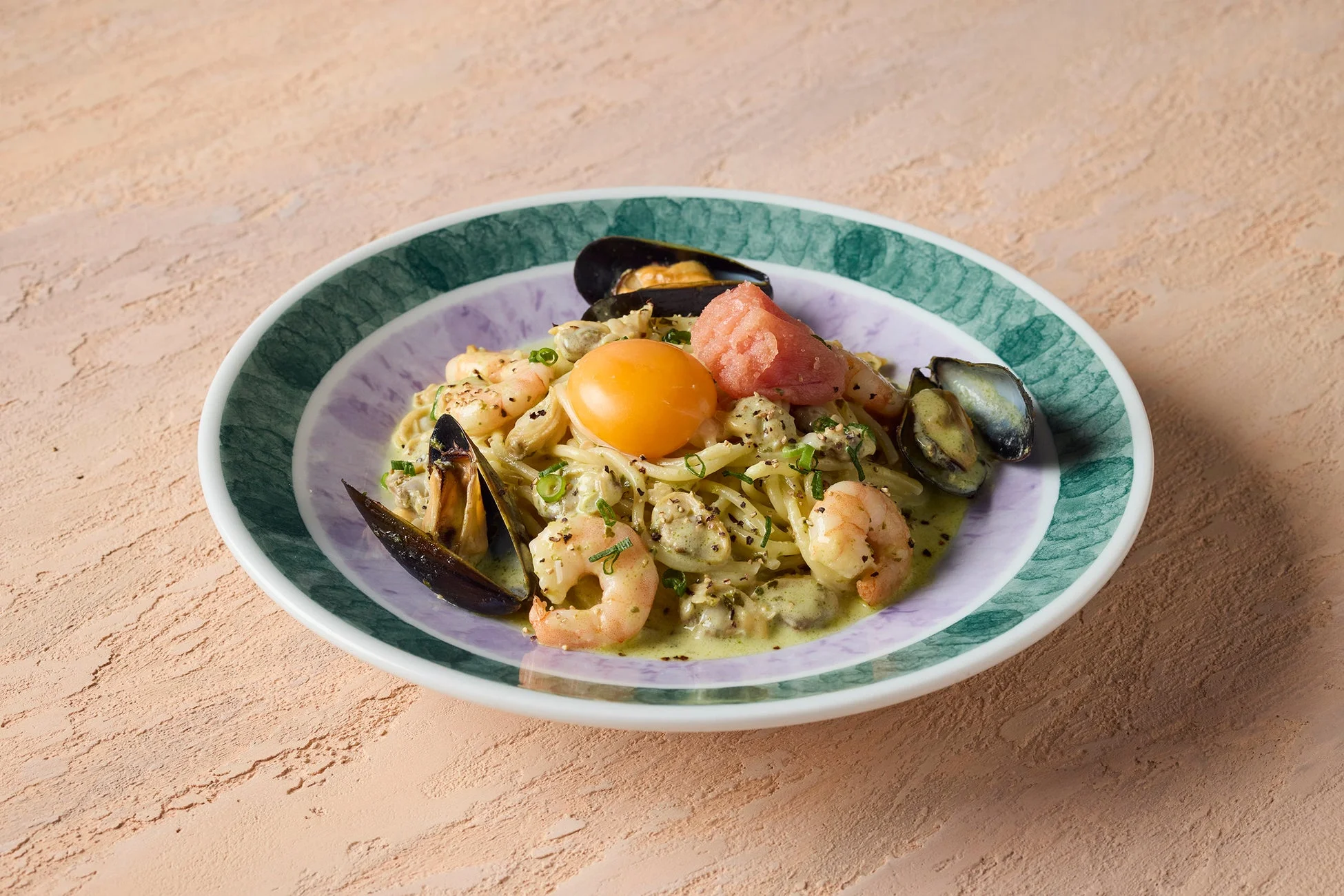 エビ、ムール貝、卵黄、明太子が贅沢にトッピングされた、クリーミーな海鮮パスタ