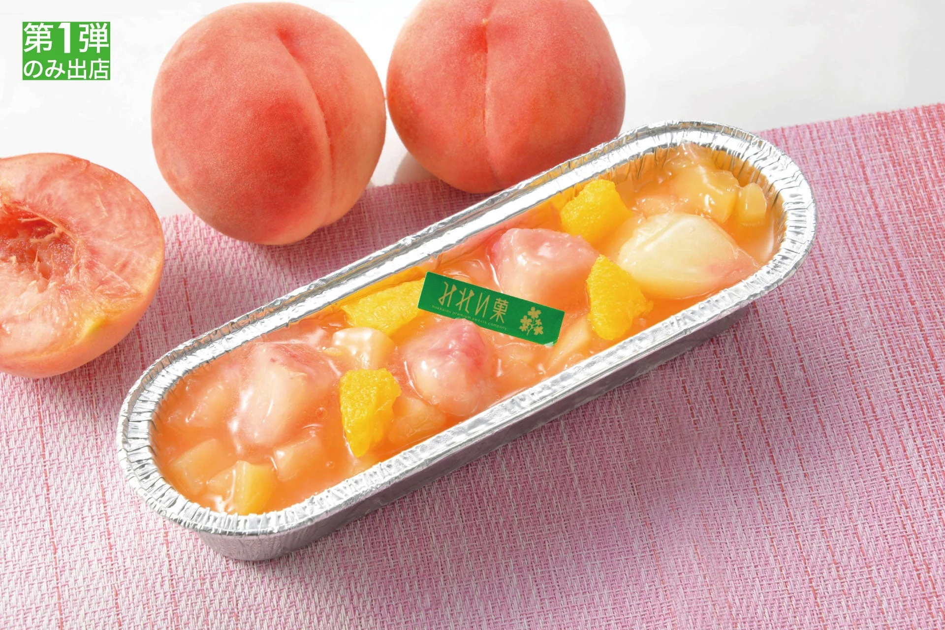 新鮮な桃と、桃の果肉やオレンジが入ったアルミ容器入りのデザート