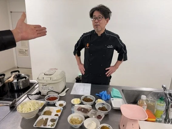 料理教室でシェフが参加者に向けて説明している様子