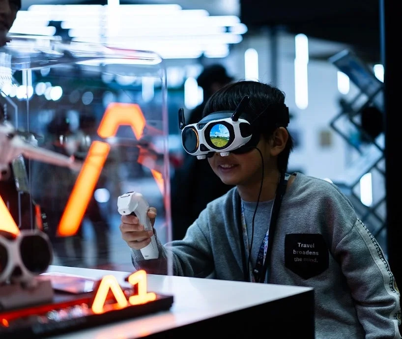 VRゴーグルとコントローラーを操作し、笑顔で楽しむ少年