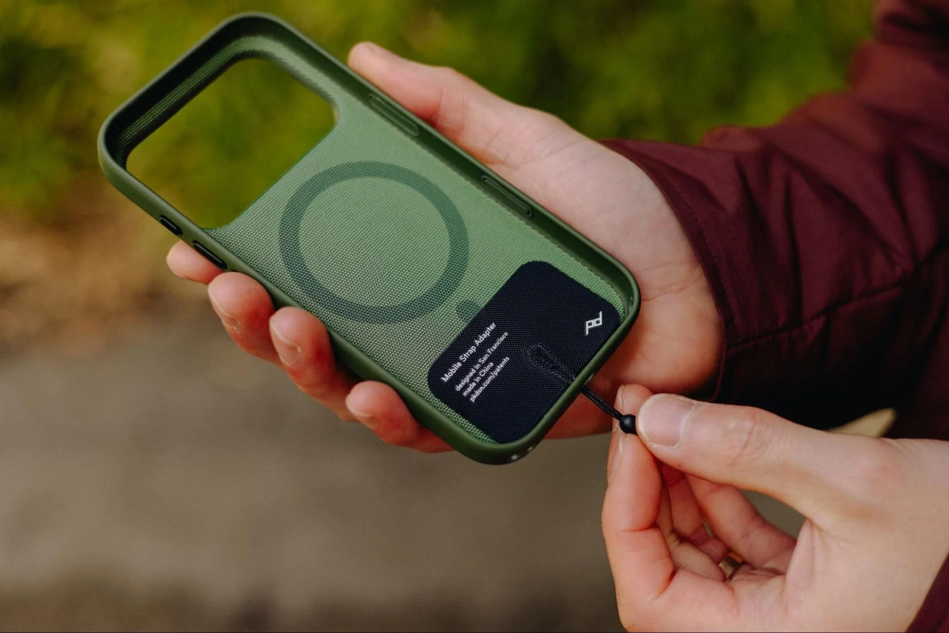 スマホケースに装着されたモバイル ストラップ アダプター