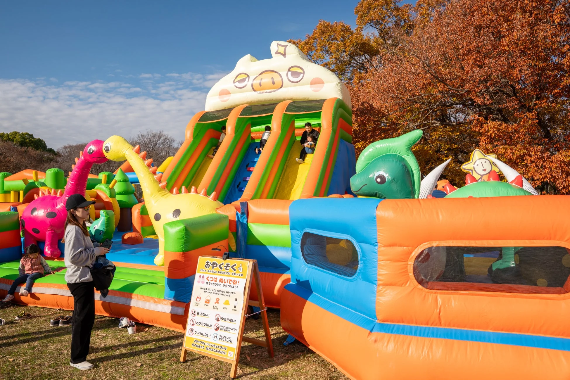 秋の紅葉を背景に設置された大型エア遊具
