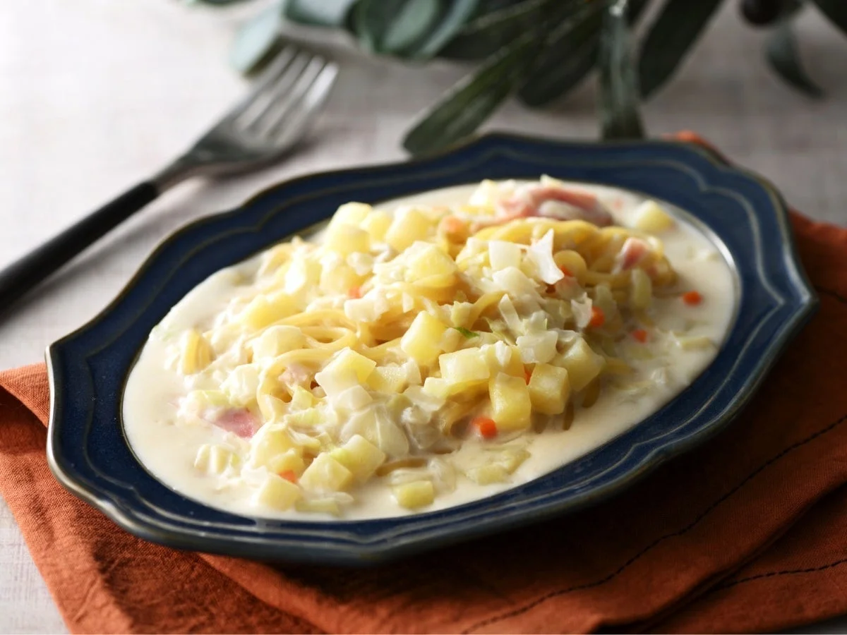 紺色の皿に盛られたクリーミーなパスタ料理