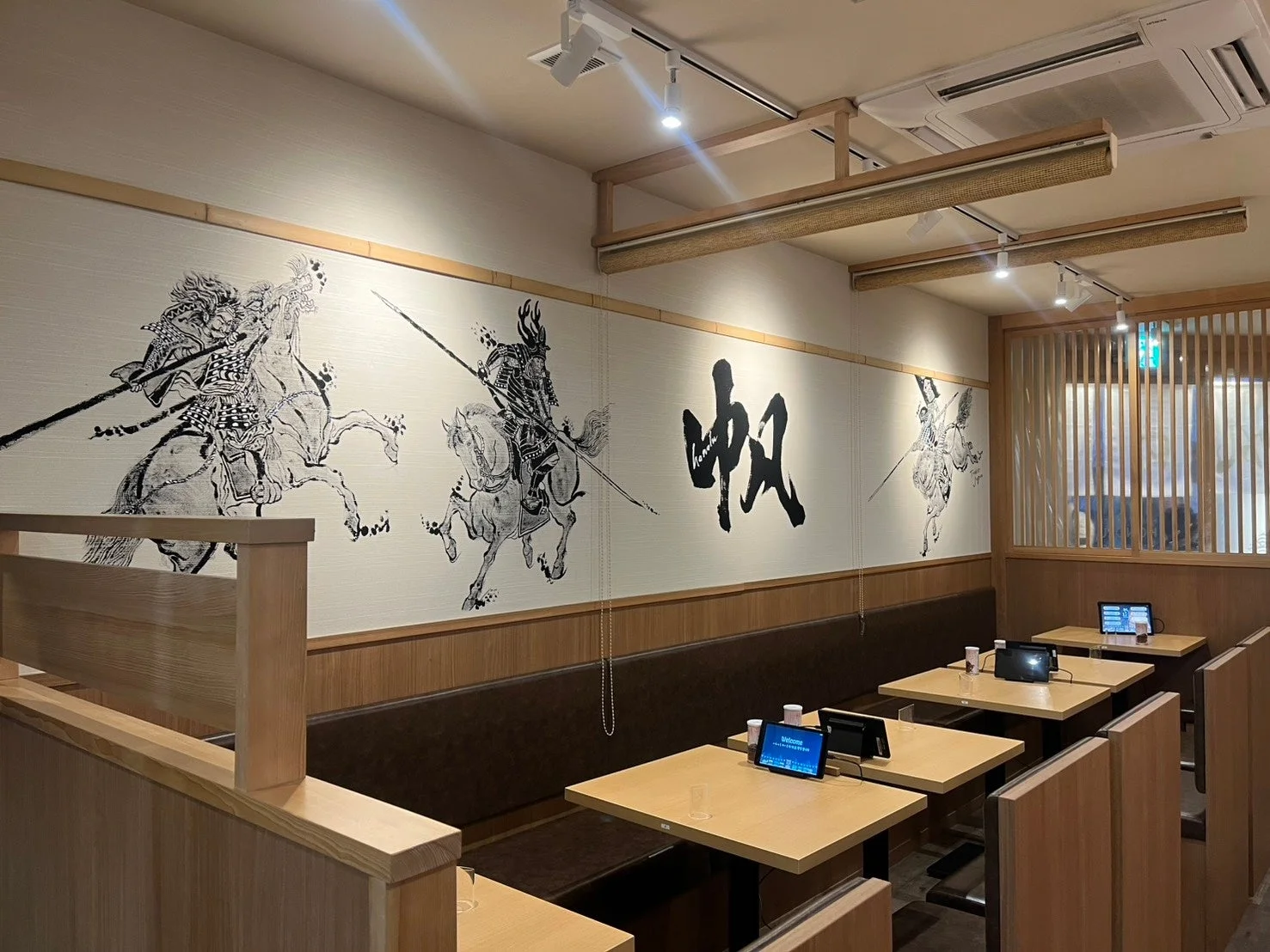 武士と書道の壁画が特徴的な和風モダンな飲食店内の様子