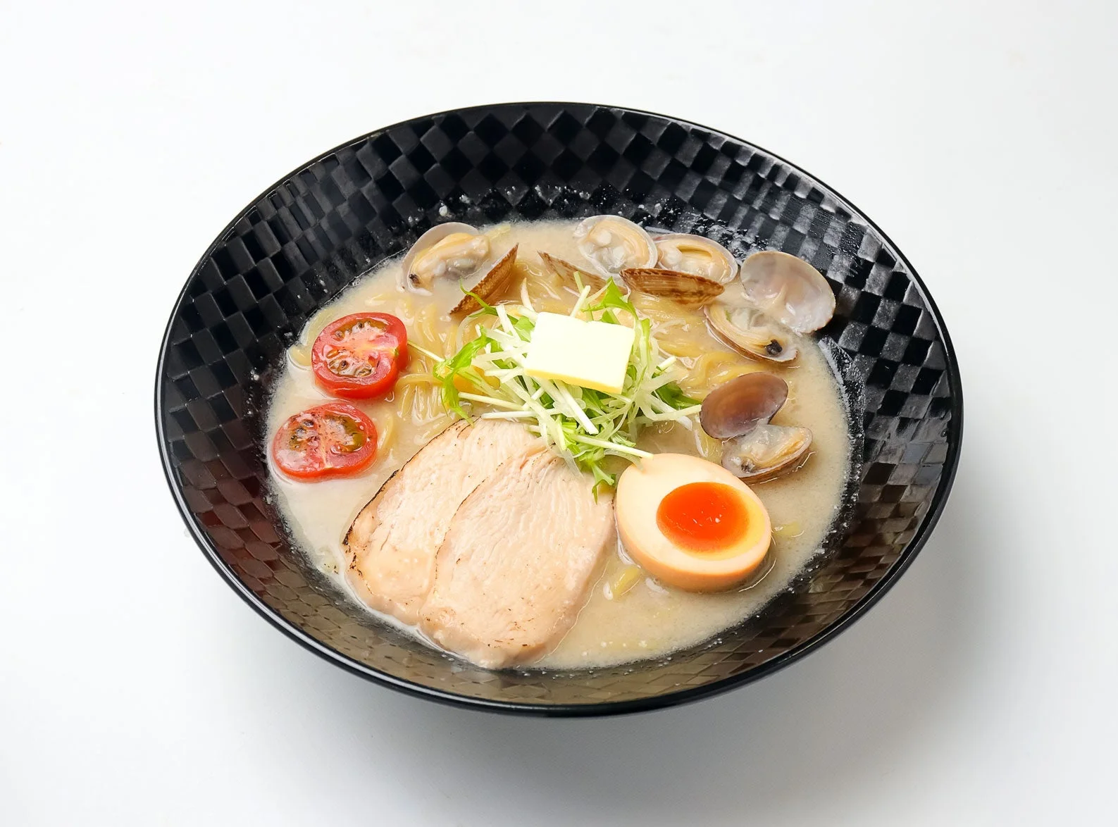 あさり、鶏チャーシュー、味玉などがトッピングされたラーメン