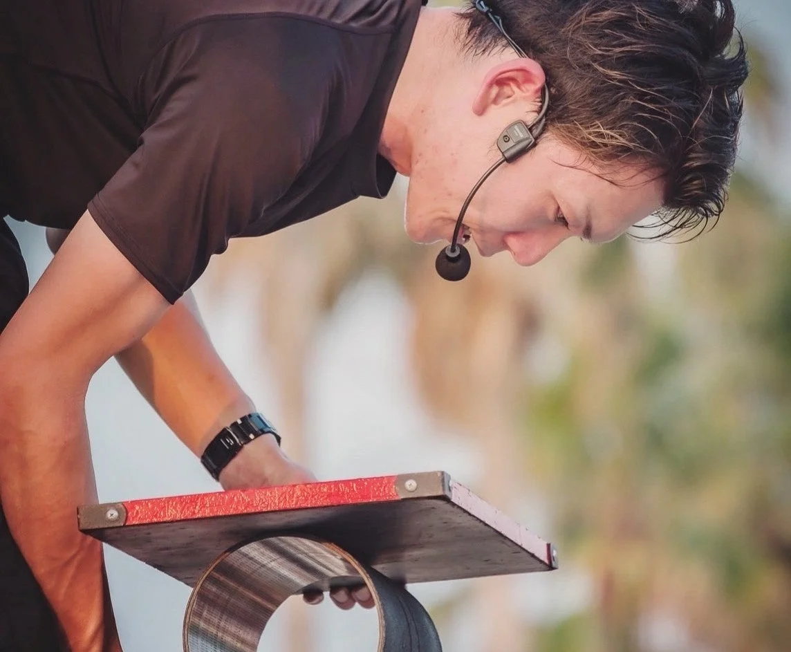 バランスボードに手を置いて集中する男性パフォーマー