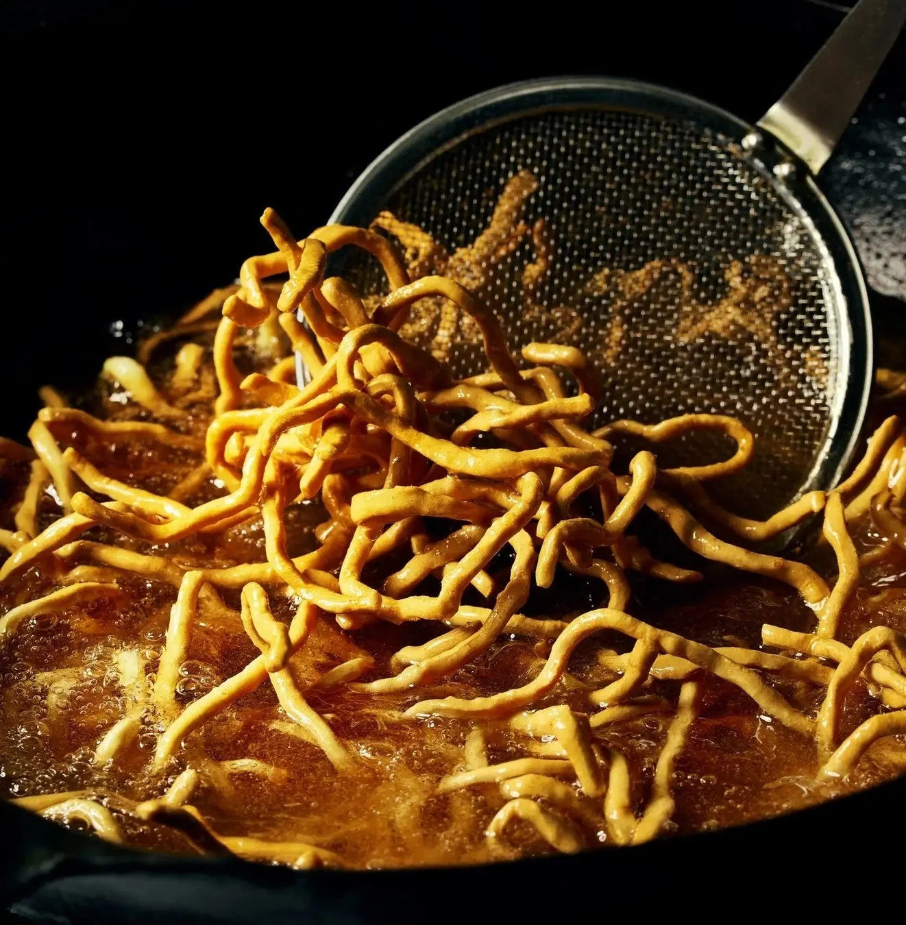 自家製麺を揚げる様子