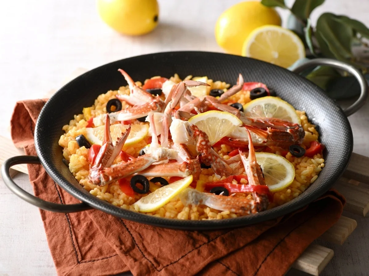 カニの身とレモンスライスが鮮やかに盛り付けられたシーフードパエリア