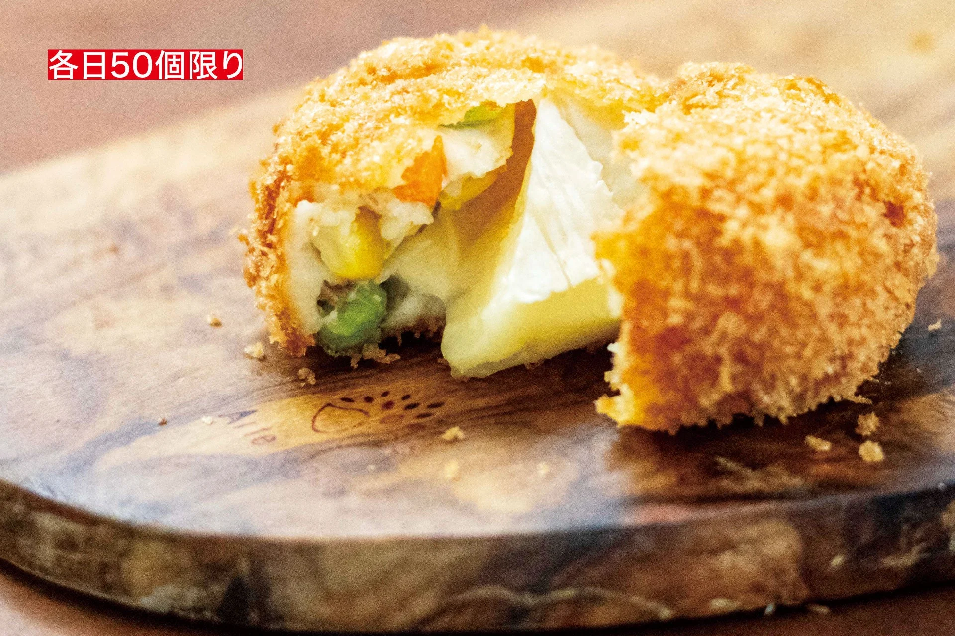 サクサクに揚がった衣の中から、とろりと溶けたチーズとコーン、グリーンピースが顔を出す揚げ物