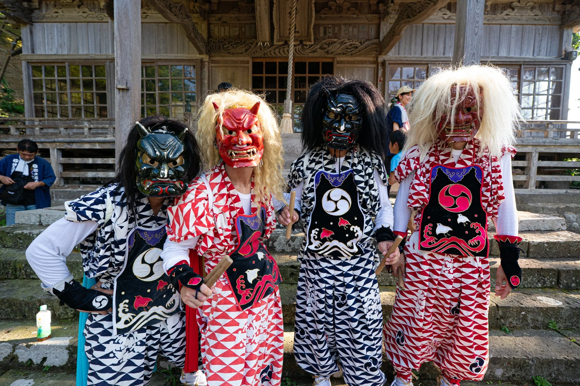 日本の伝統的な仮面と衣装を身につけた人々