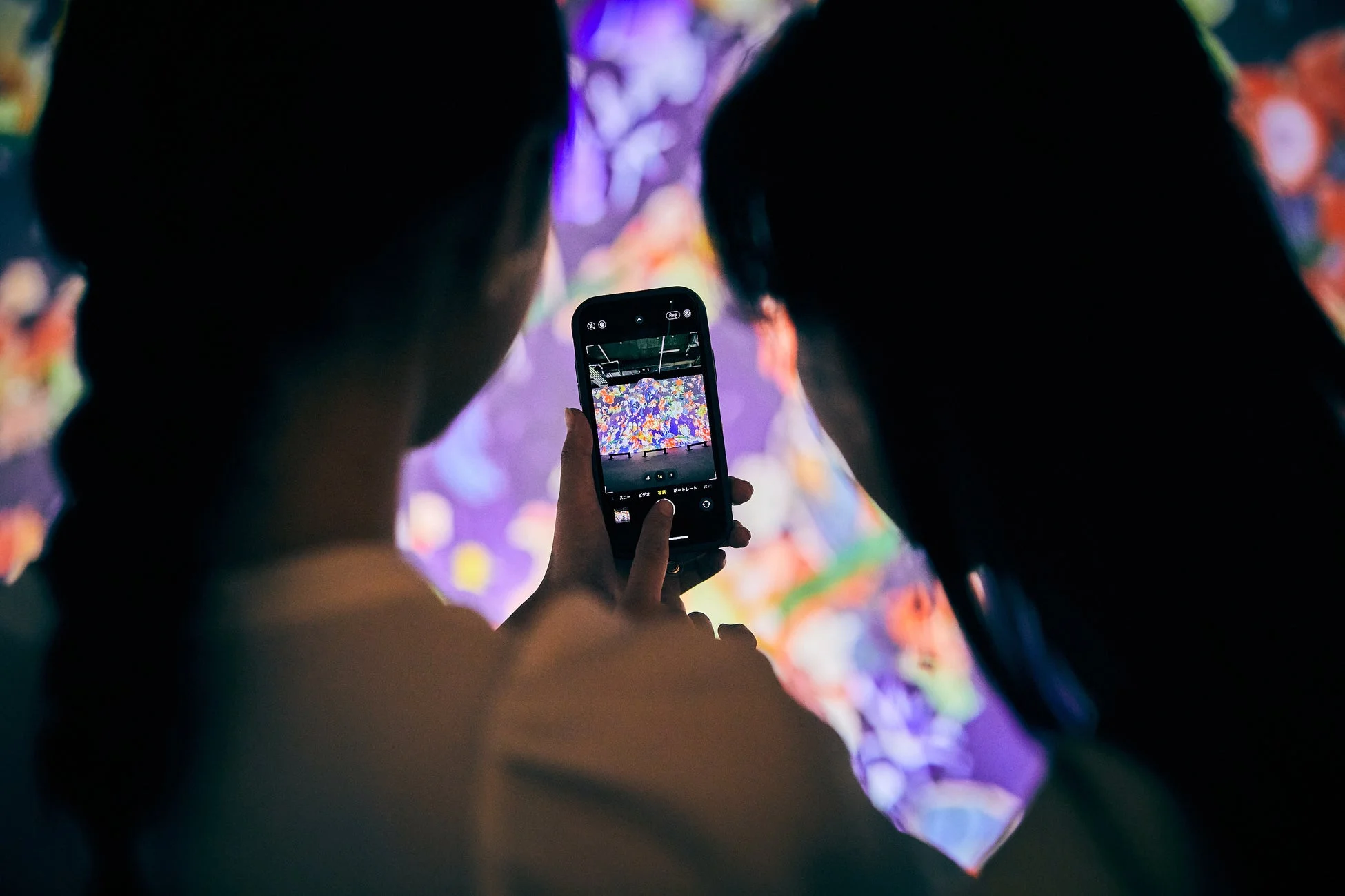 スマートフォンでデジタルアートを撮影する様子