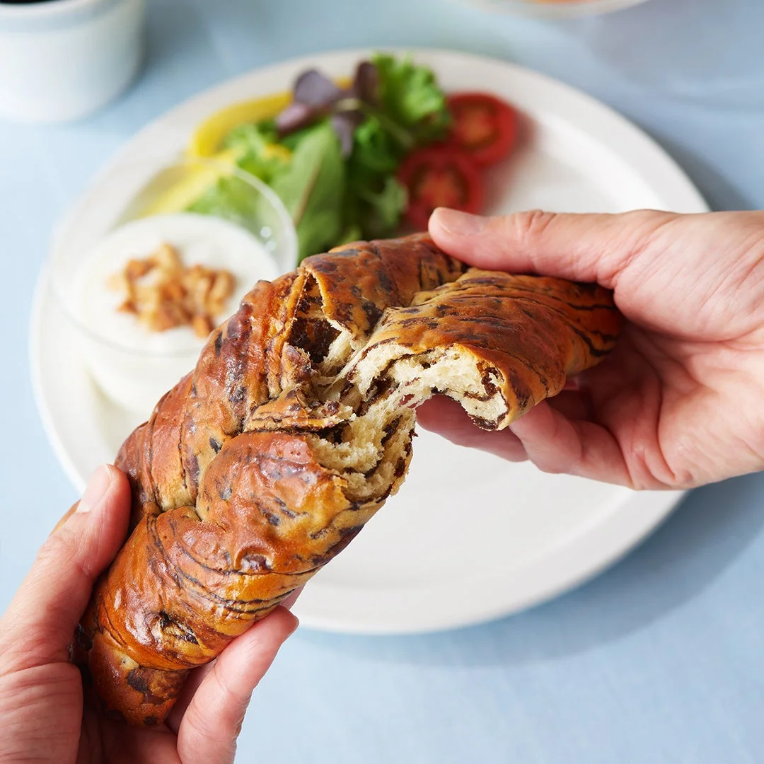 手がチョコレートが練り込まれたパンをちぎっている様子