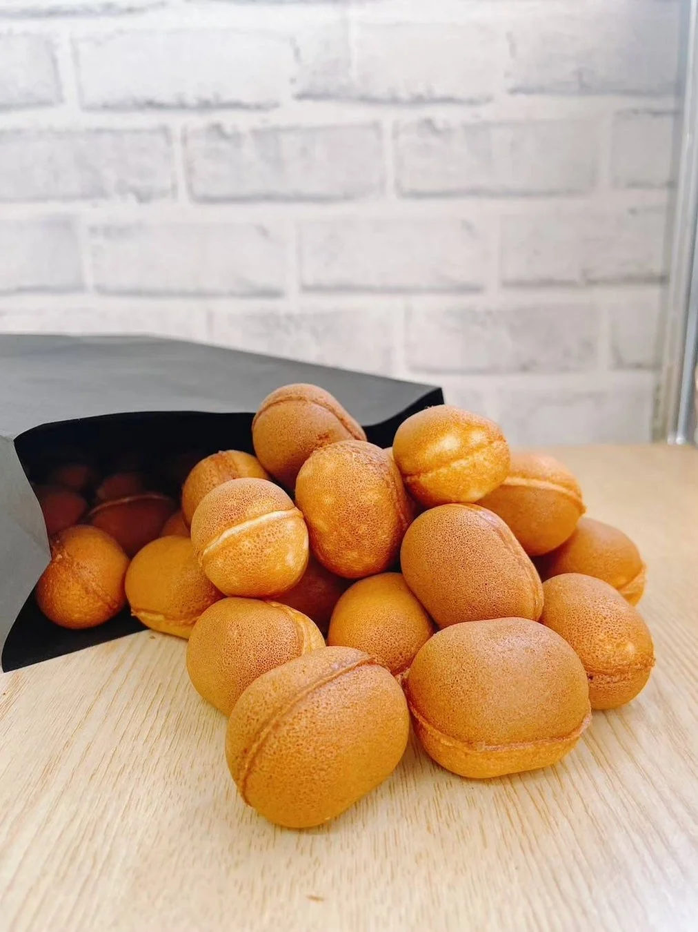 卵形の小さな焼き菓子が木製のテーブルに山積みにされた画像