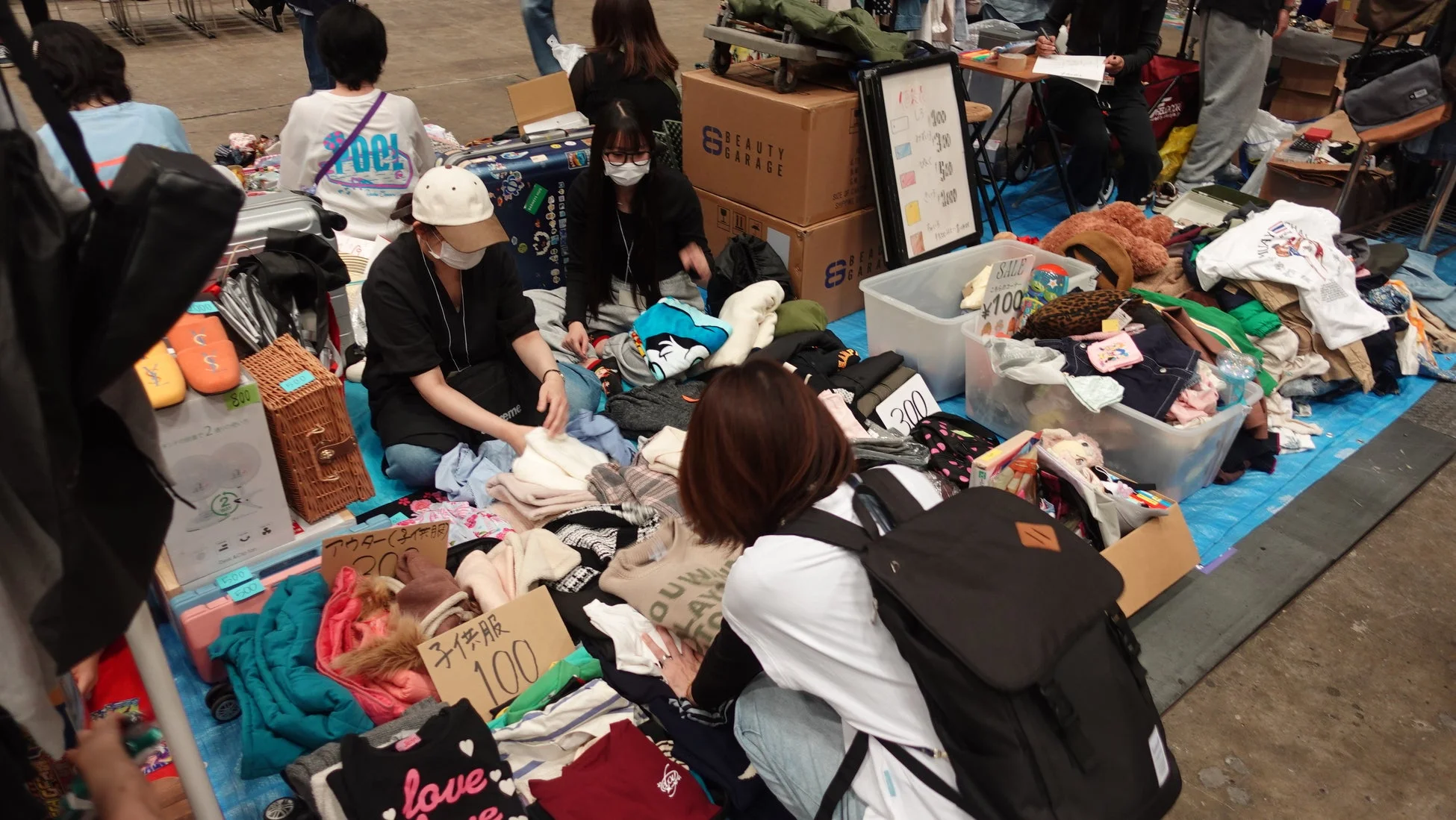フリーマーケットで洋服や雑貨を物色する人々